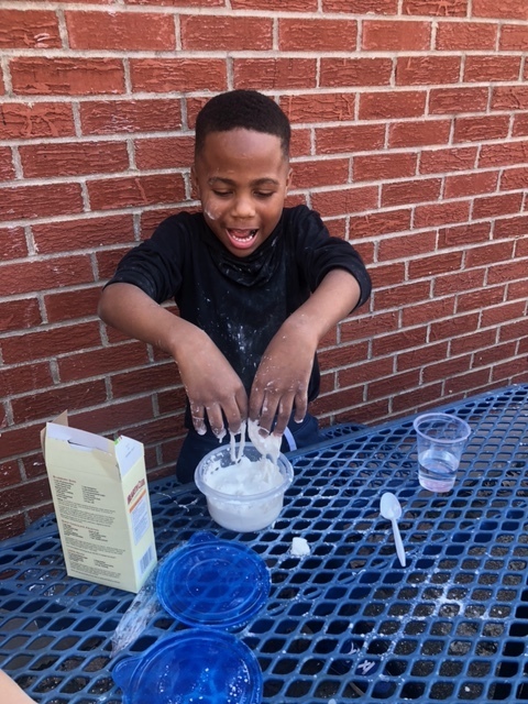 student with hands in oobleck